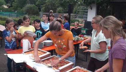 Am Zeltlager wird Pizza ausgeteilt