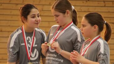 Drei stolze Spielerinnen mit der Medaille um den Hals