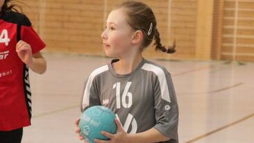 Junge Handballspielerin im Jugendhandball mit Ball in der Sporthalle, Spielsituation im Nachwuchs-Handballverein