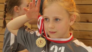 Ein Mädchen zeigt seine Medaille