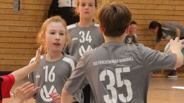 Mehrere Kinder im Jugendhandball während einer Spielsituation in der Sporthalle, Mannschaftsspiel im Nachwuchs-Handballverein