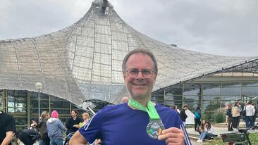 Ein Mann hält stolz seine Medaille ins Bild