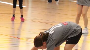 Jugendhandball Spielerin kontrolliert den Ball während einer Spielsituation in der Sporthalle, Nachwuchs-Handball im Verein